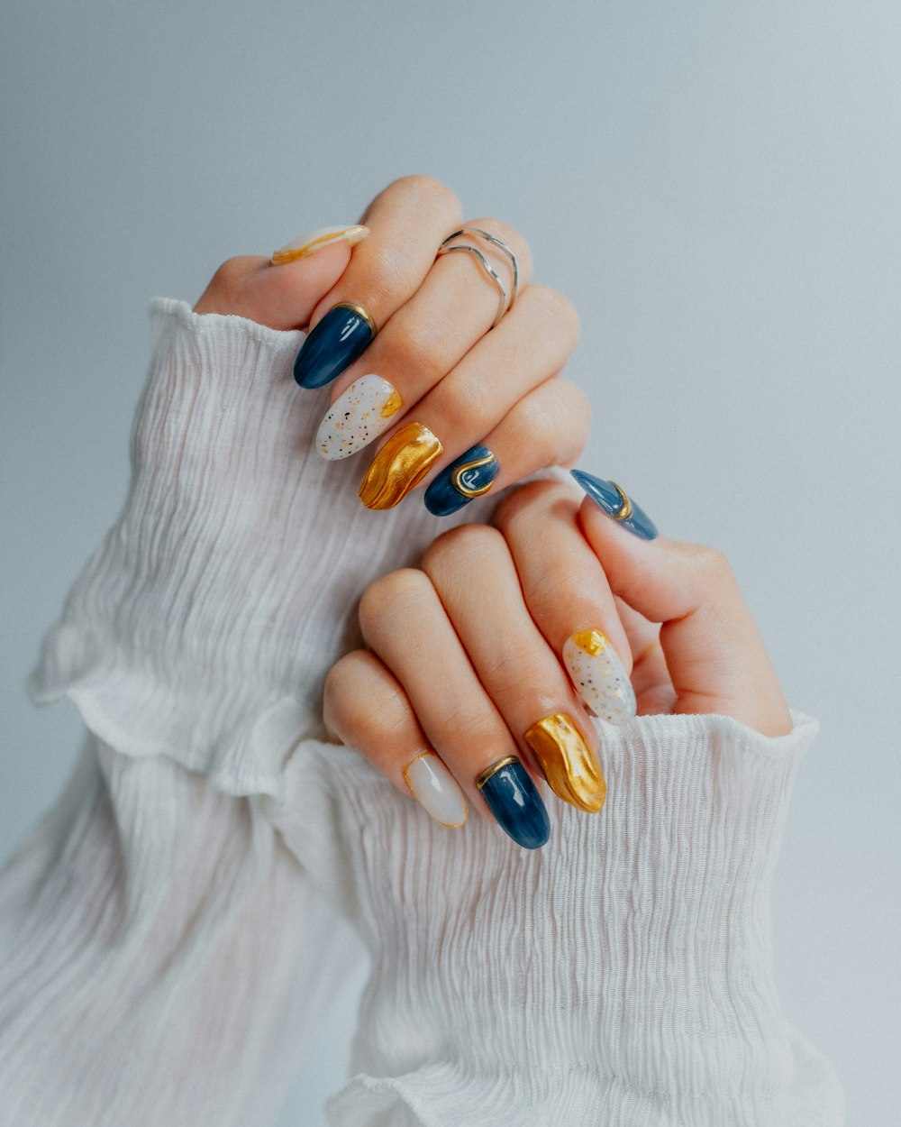 Uñas azul marino, oro y blanco